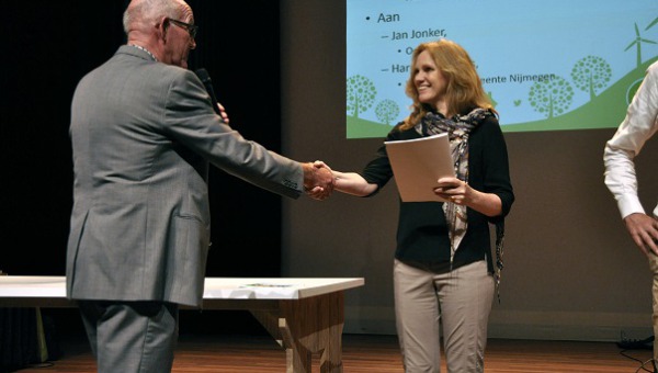 Harriet Thiemens reikt handboek energie opwek uit tijdens Duurzaamheidscafe Nijmegen